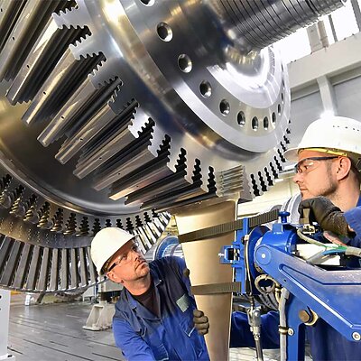 Maschinenbau, zwei Männer an einem riesigen Zahnrad